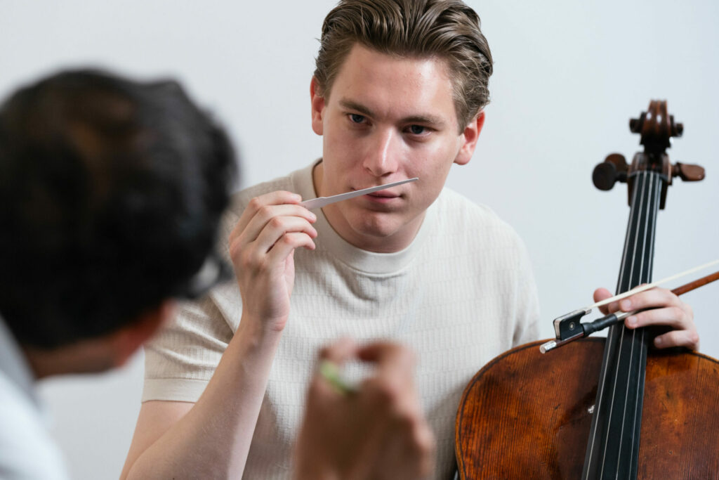 Un homme sent un testeur de parfum et tient un instrument à corde