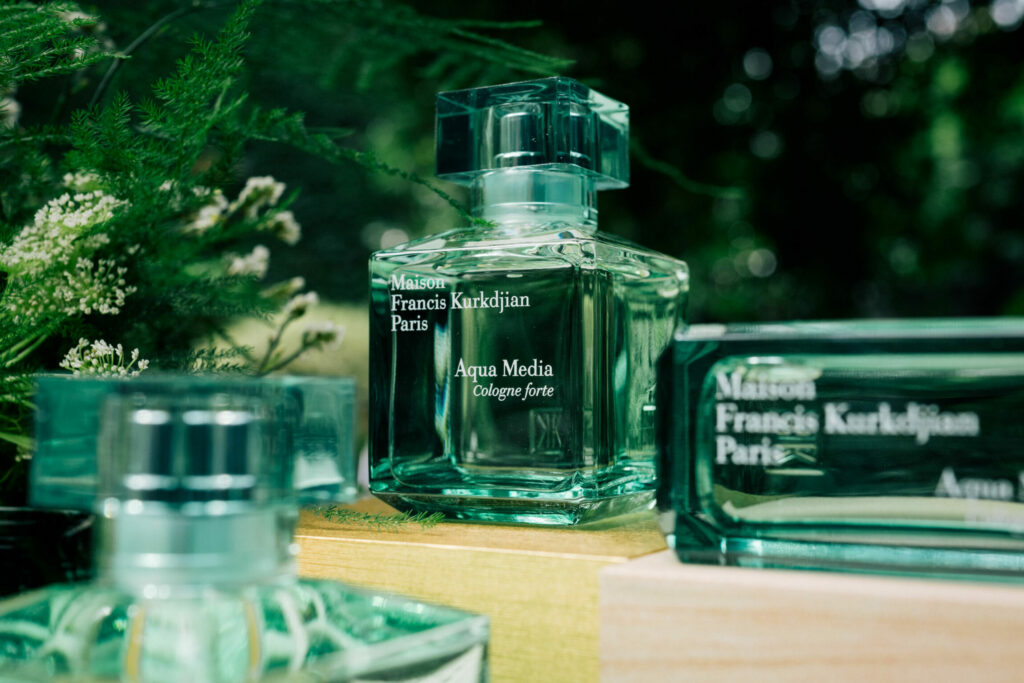 Mise en avant d'un flacon de parfum entouré de verdure