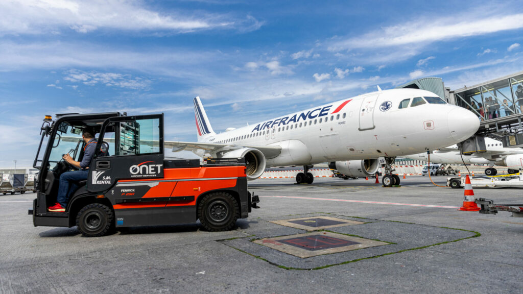 Tarmac d'avion avec un avion et un fenwick.