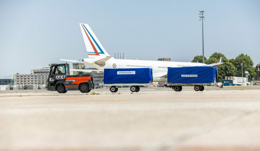 Tarmac d'avion avec en arrière plan un avion et devant un fenwi