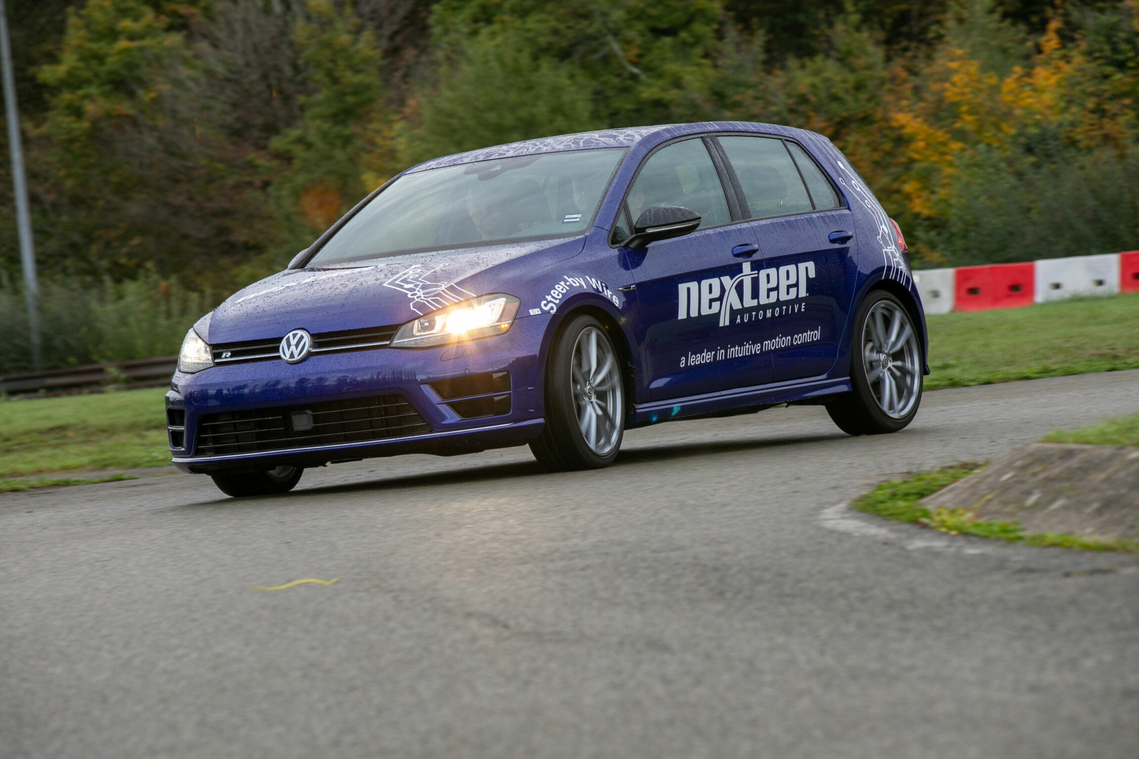 Voiture bleue sur un circuit automobile.