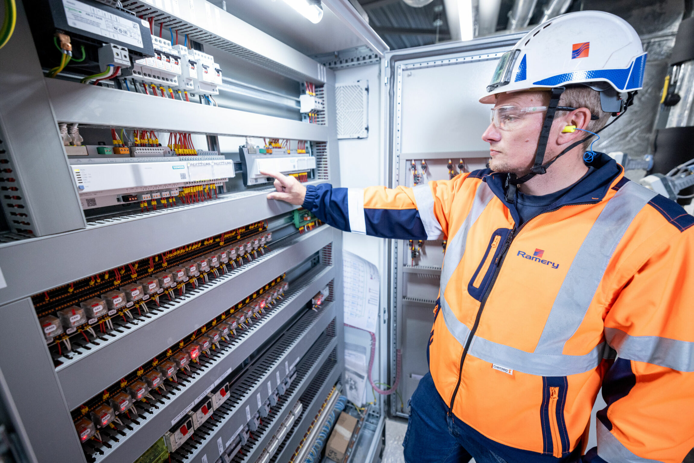 Un technicien en électricité devant un tableau de raccordement.