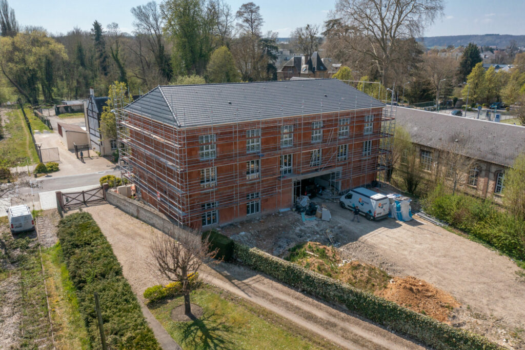 Photographie de drone d'une maison en construction avec échafaudage.