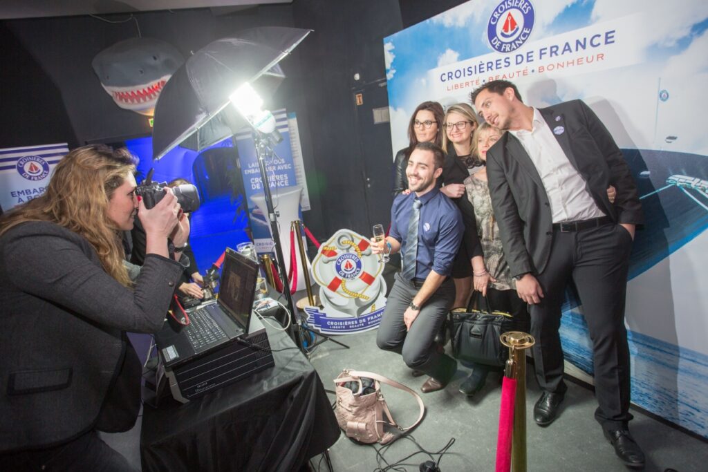 Backstage d'une prise de vue devant un photocall : cinq personnes qui posent devant photocall Croisières de France