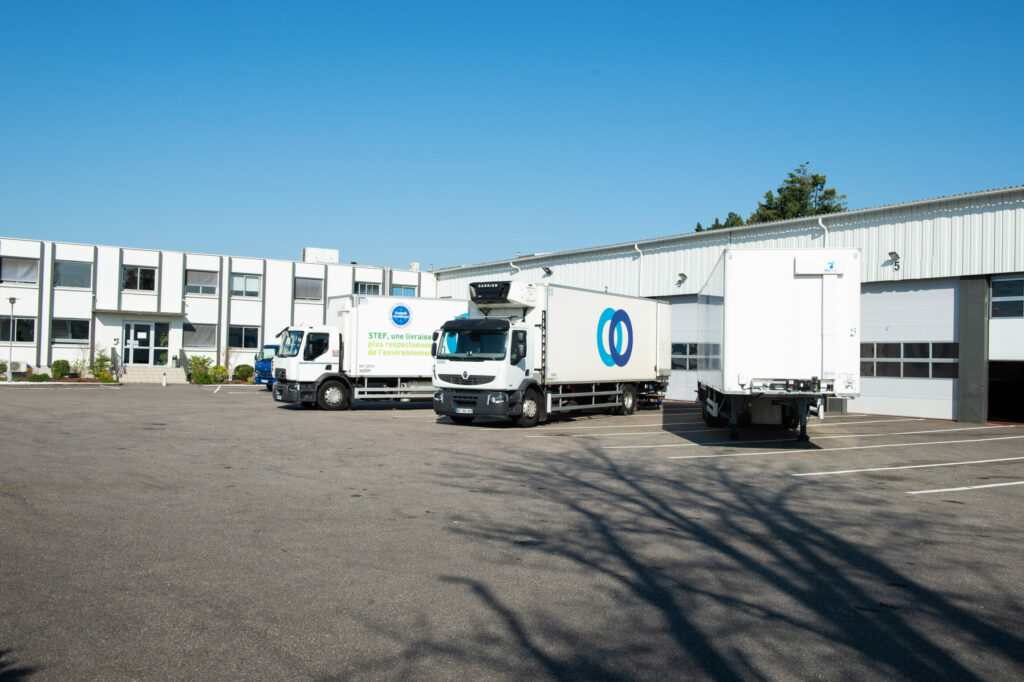 Quai de livraison avec trois camions en train d'être chargés.