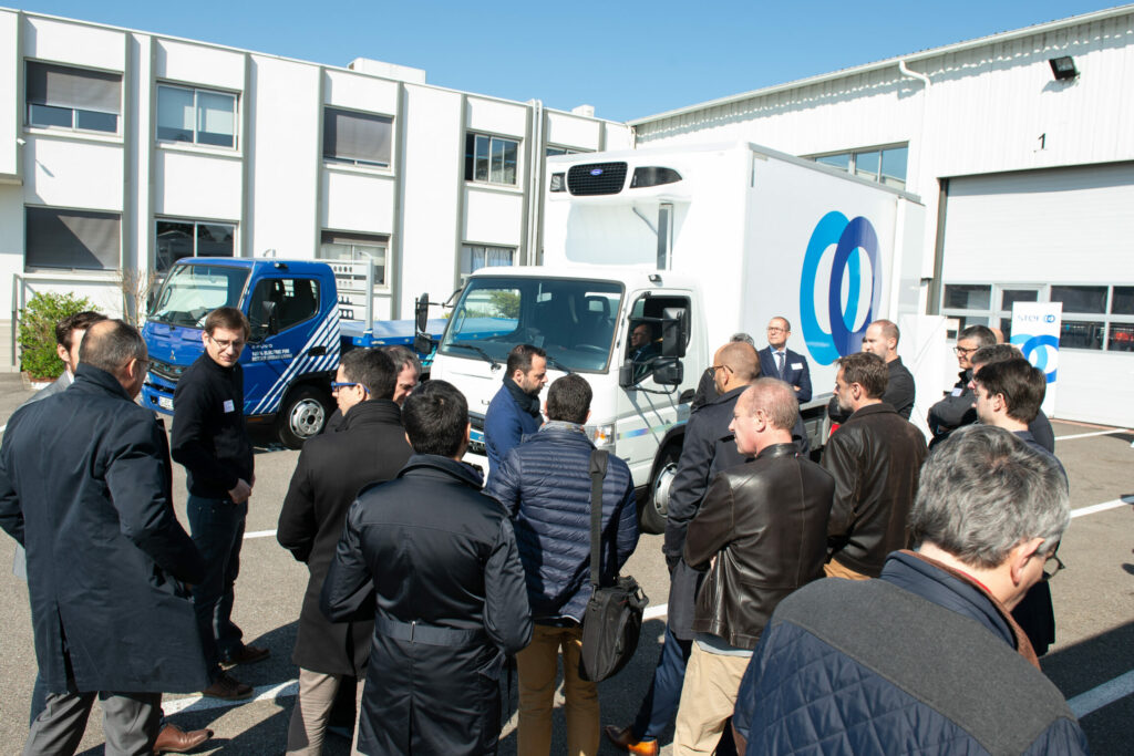 Groupe de collaborateurs de dos, qui découvrent le nouveau camion Stef.