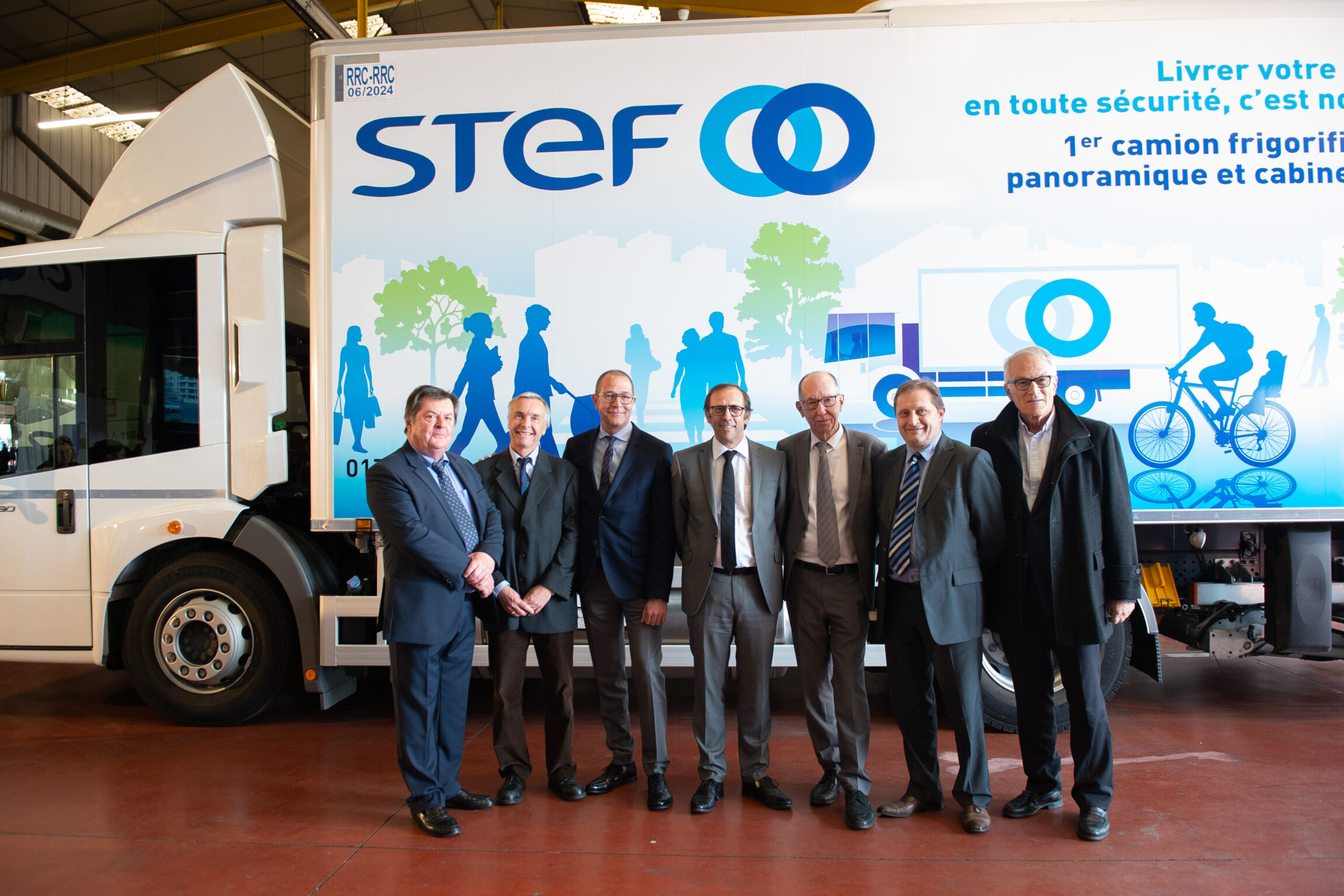 Groupe de sept hommes se tenant devant le nouveau camion Stef Econic