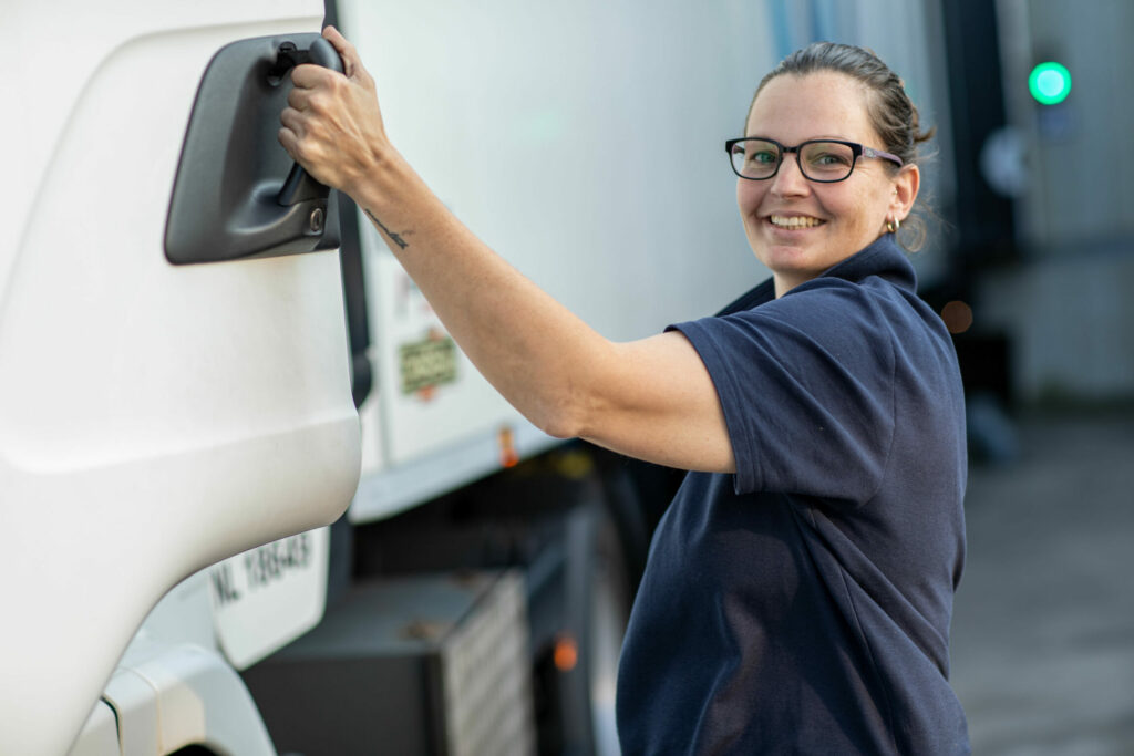 Portrait d'une chauffeuse de camion Stef qui monte dans son camion.