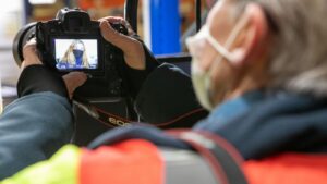 Un photographe en train de prendre le portrait d'un collaborateur portant un masque FFP2