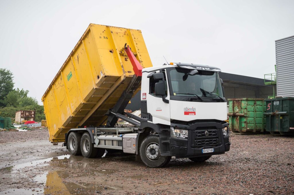 Un camion en train de descendre sa remorque sur un chantier