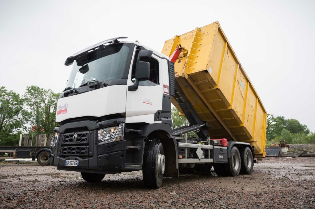 Un camion en train de descendre sa remorque sur un chantier