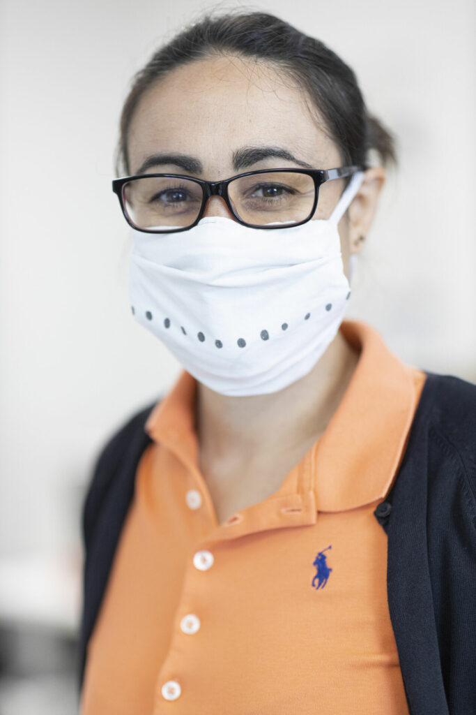 Portrait d'une femme à lunettes portant un masque chirurgical.