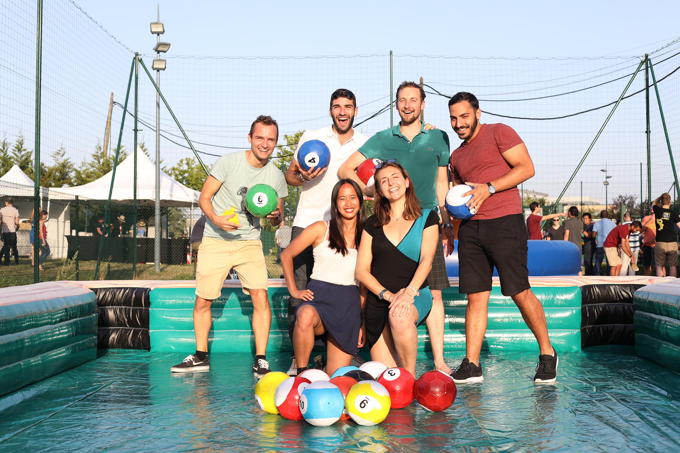 Photo de groupe de collaborateur pendant une journée de CE Dassault Systemes dans en piscine avec des ballons.