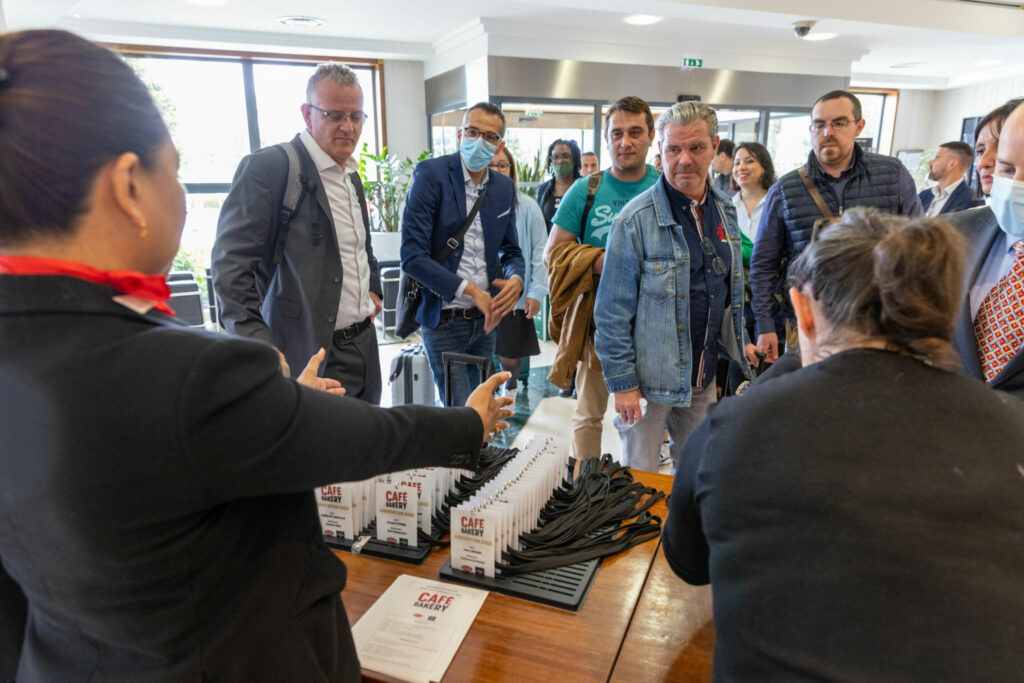 Femme qui présente des pass aux collaborateurs qui arrivent sur le lieu de l'événement Café Bakery.