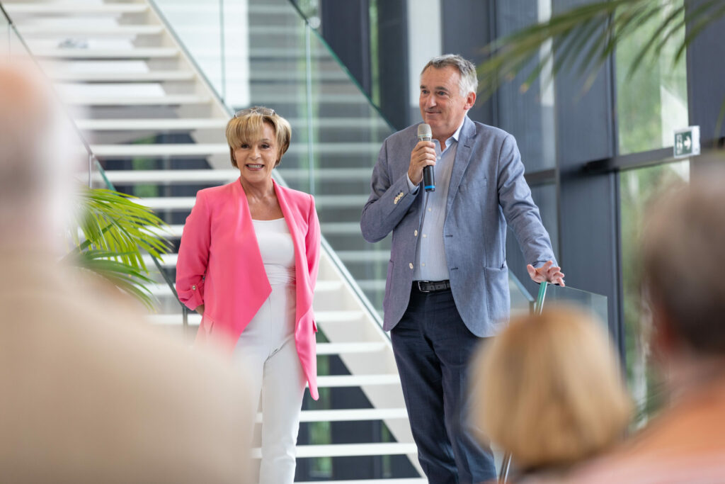 Deux personnes en train de donner un discours face à des collaborateurs.