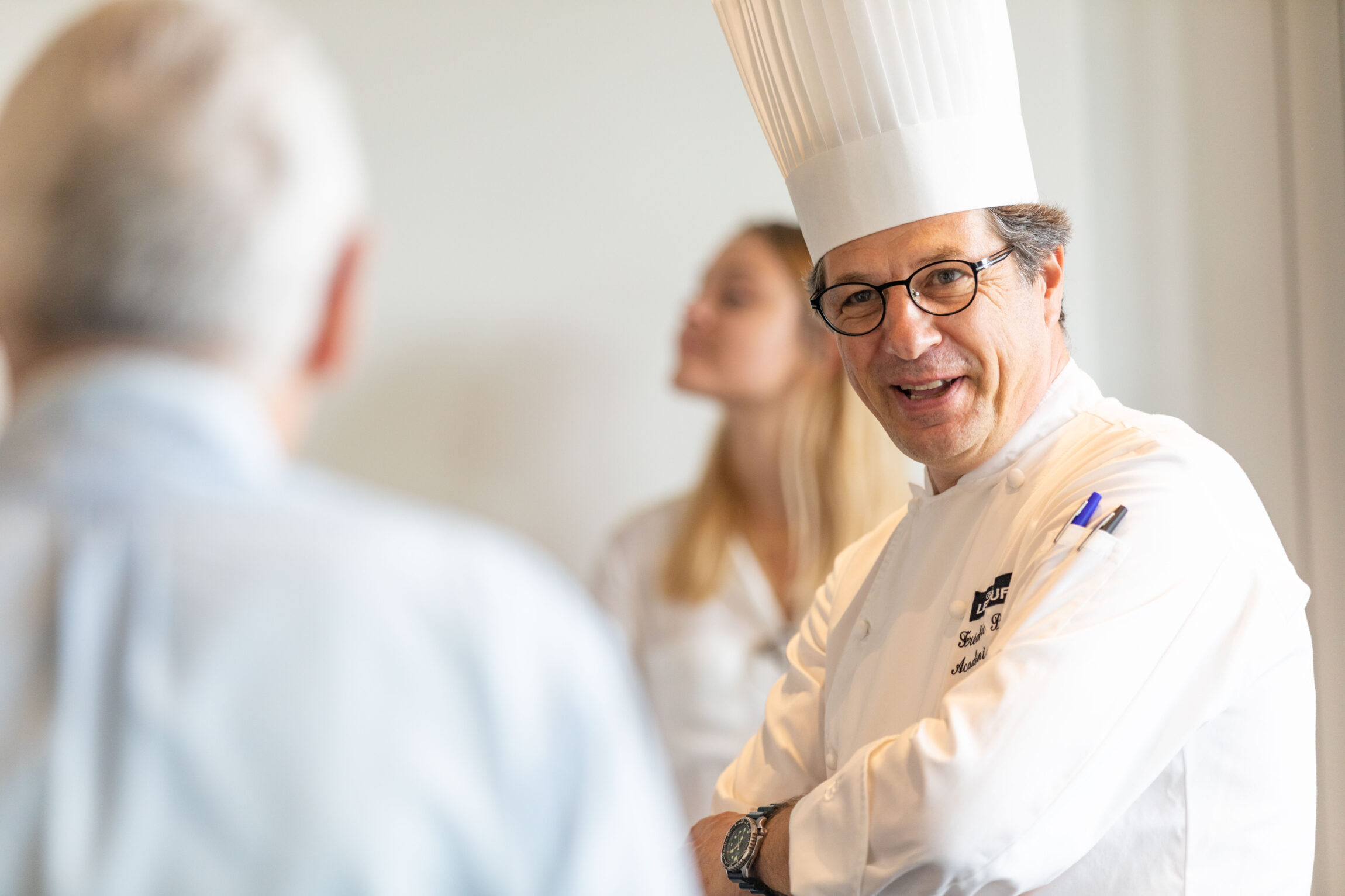 Un chef cuisinier discute avec un homme.