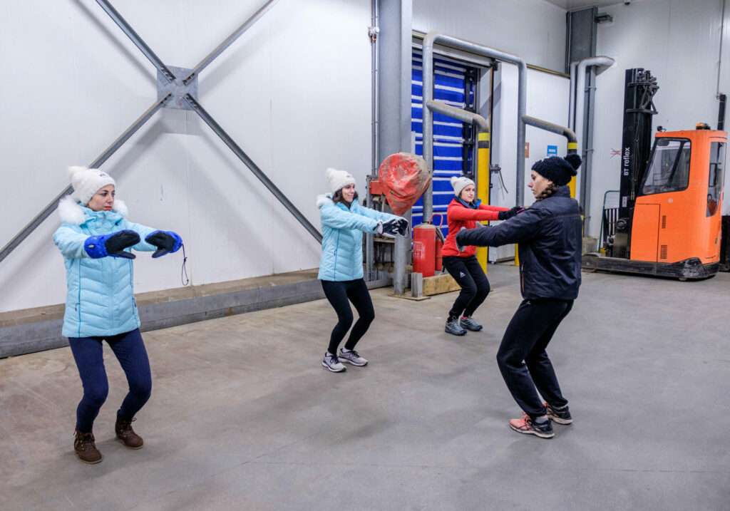 Un groupe de femme qui s'échauffe avec une course dans un entrepôt STEF