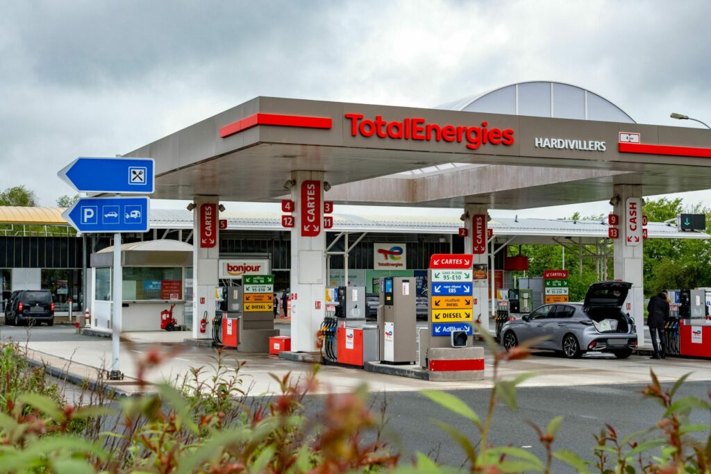 Focus sur les pistolets de la station service et le logo Total Energies